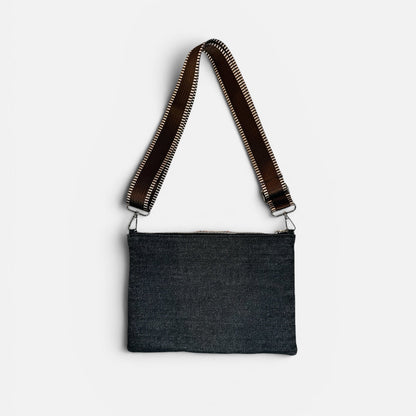 Black crossbody bag with brown strap on a white background