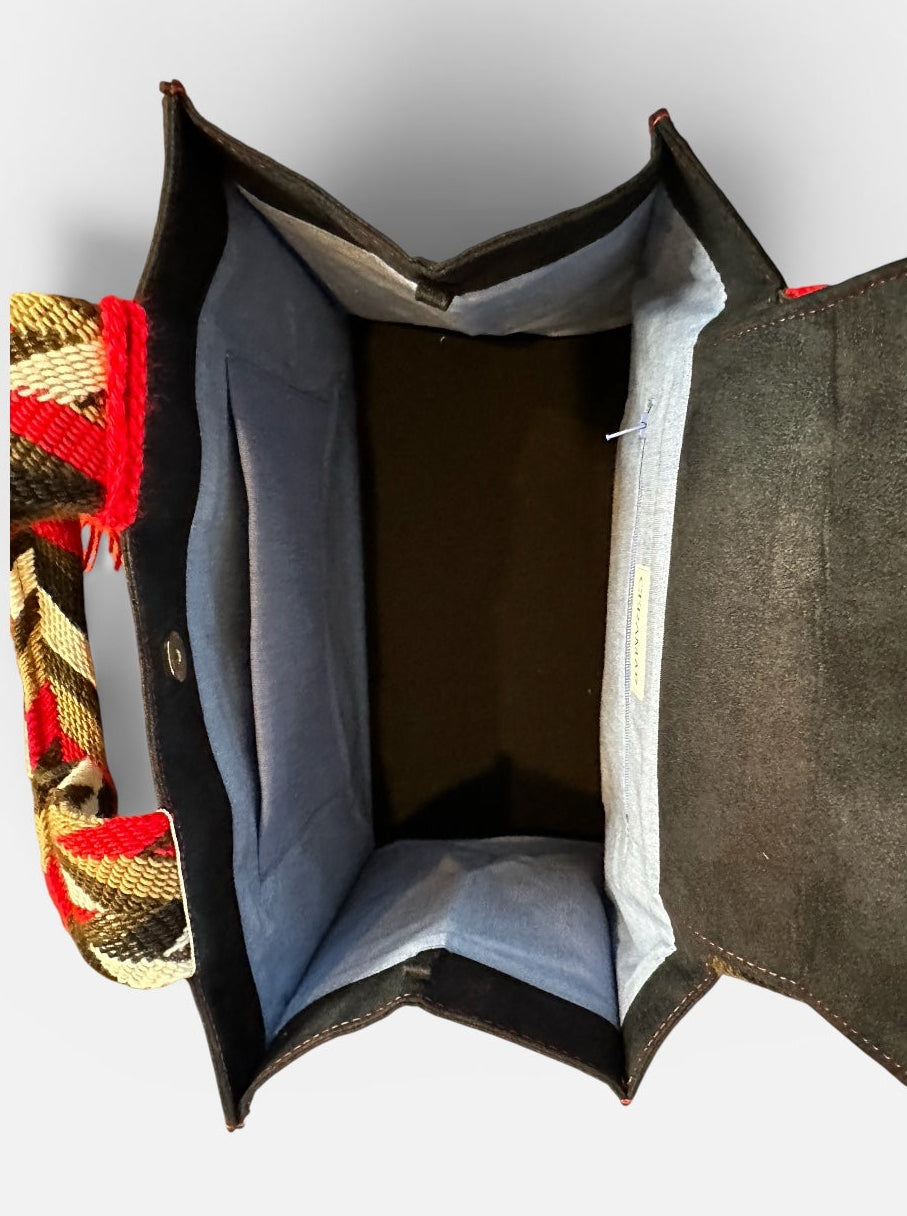 Open black handbag with a patterned interior on a white background