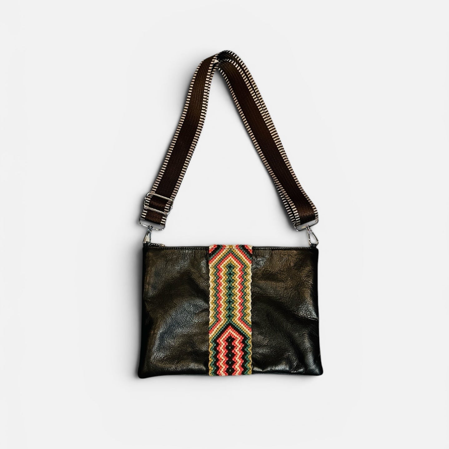 Black leather handbag with colorful strap on a white background
