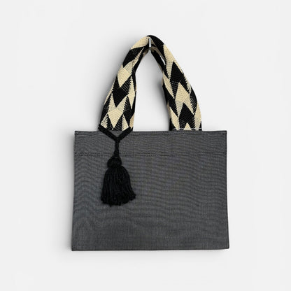 Gray tote bag with a black and white striped handle on a light gray background