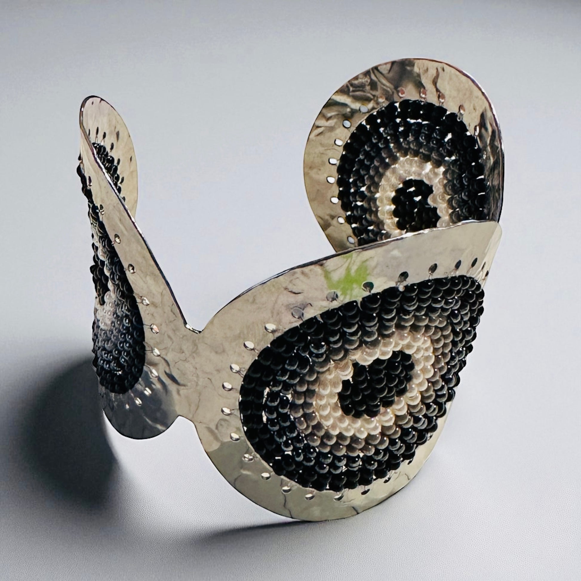 Cuff bracelet with black and white pattern on a gray background