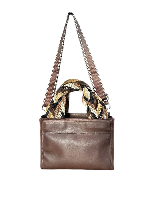 Brown leather handbag with a patterned scarf on a white background
