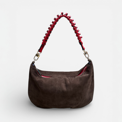 Brown handbag with a red beaded handle on a white background