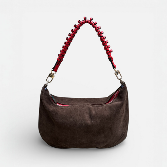 Brown handbag with a red beaded handle on a white background