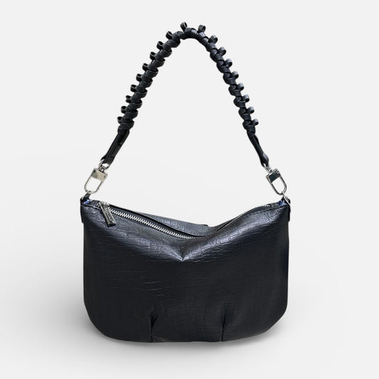Black handbag with a unique handle design on a white background