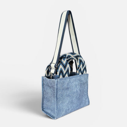 Blue denim tote bag with a patterned interior pocket on a white background