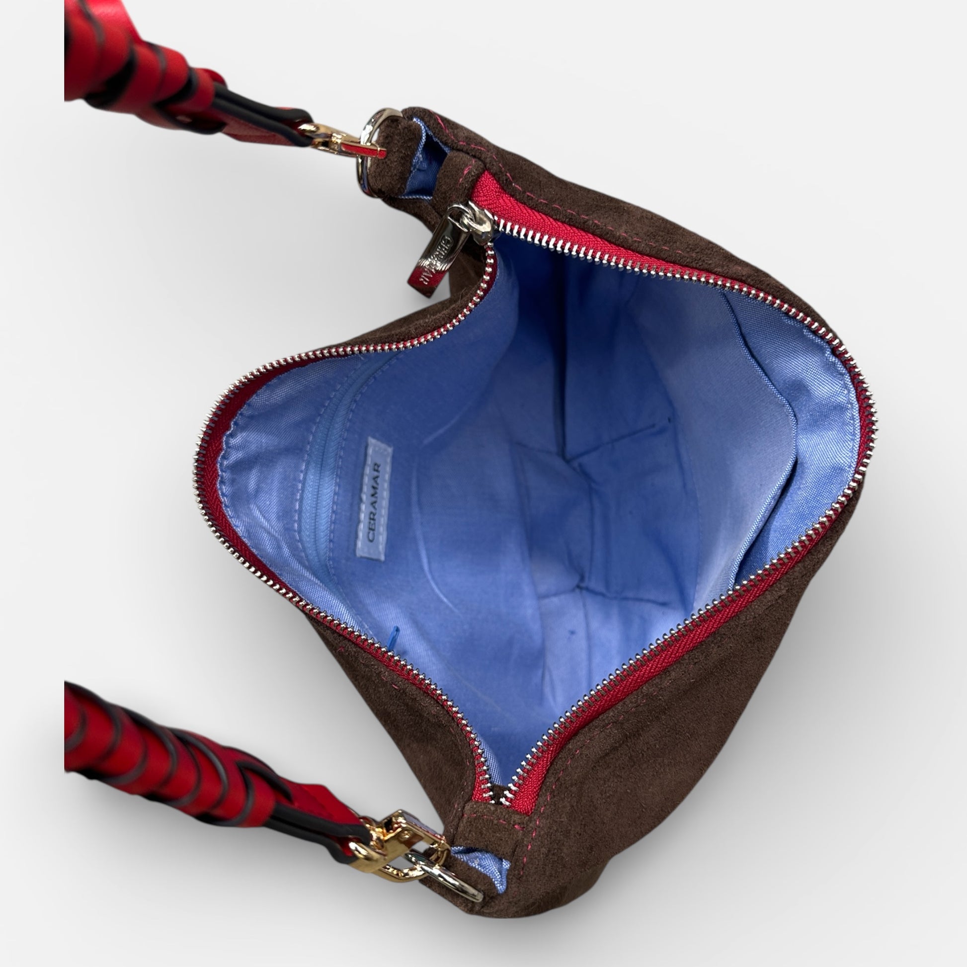 Brown bag with red interior lining and visible brand logo on a white background