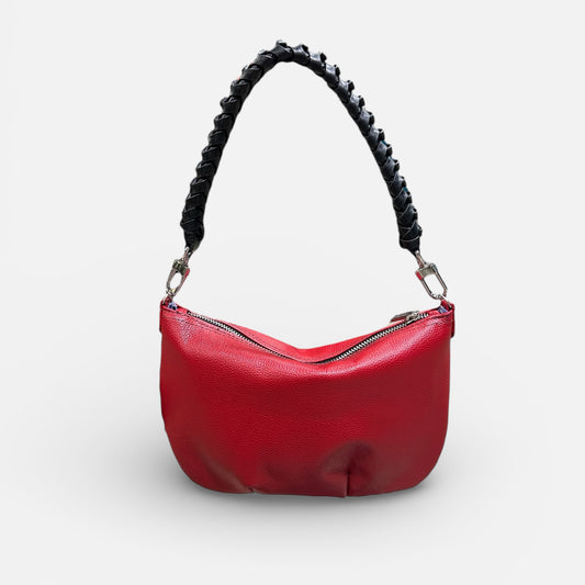 Red handbag with a black braided handle on a light gray background