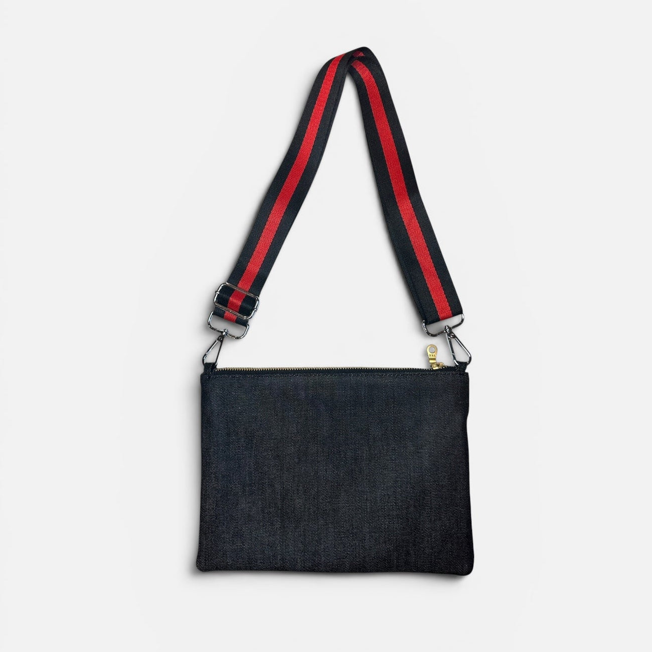 Black denim bag with red and green strap on a white background