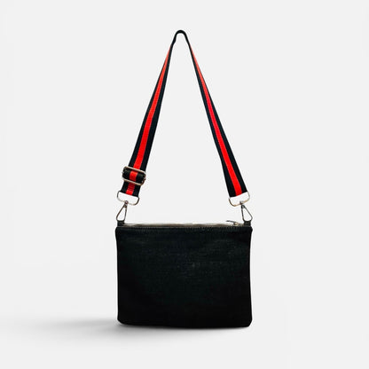 Black handbag with a red and black strap on a white background