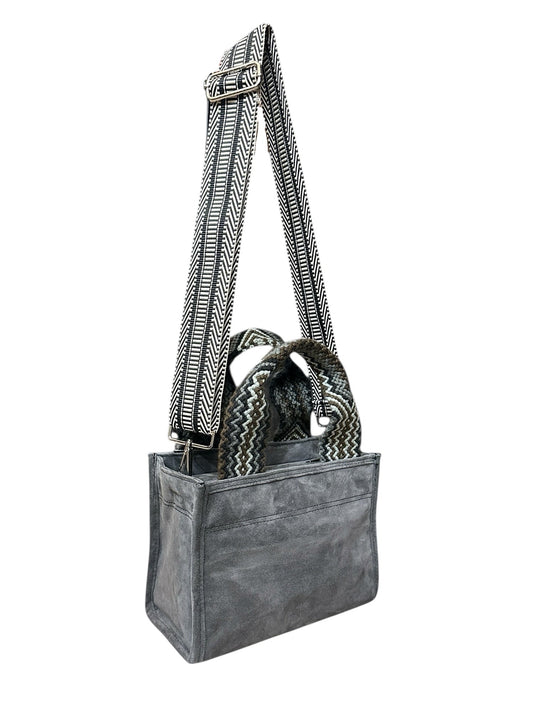 Gray crossbody bag with patterned strap on a white background