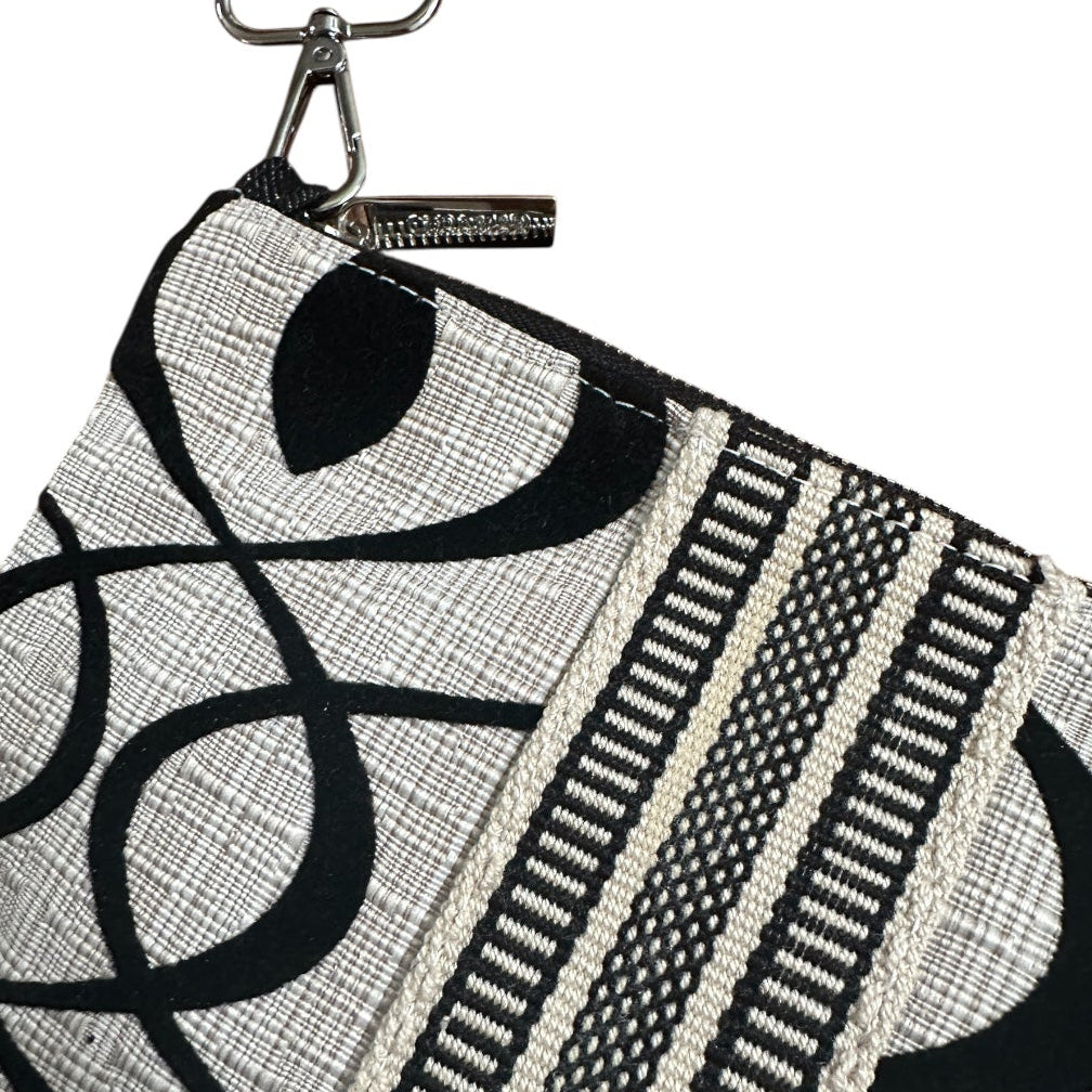 Black and white patterned pouch with a strap on a white background