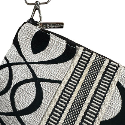 Black and white patterned pouch with a strap on a white background