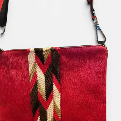 Red pouch with a patterned strap on a white background